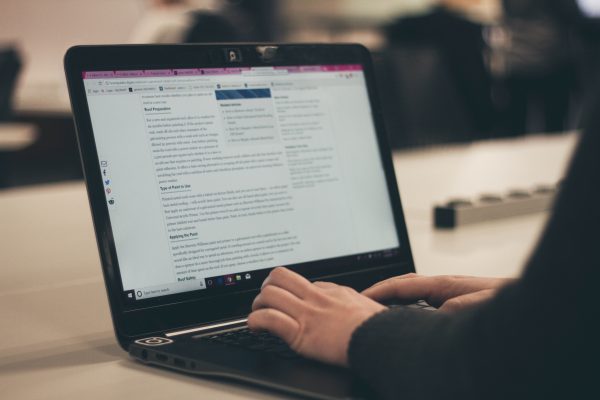 an image of a laptop on a counter with someone typing on it