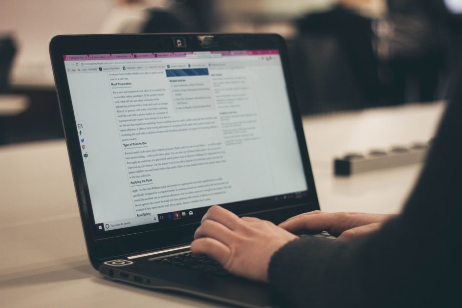 an image of a laptop on a counter with someone typing on it