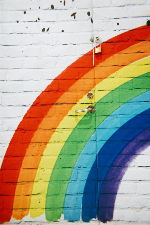 Rainbow with seven colours ROYGBIV, painted on a white brick wall representing week 7