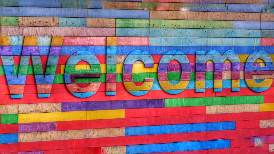 a multicoloured sign reads "welcome"