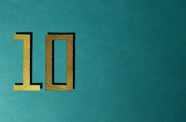 An image of the number ten in gold letters against a green wall.