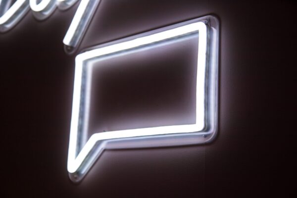 An neon sign in the shape of a comment icon
