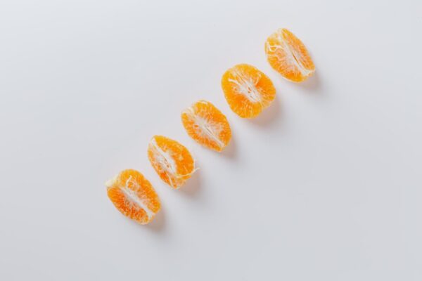 Five fresh slices of mandarins arranged in row
