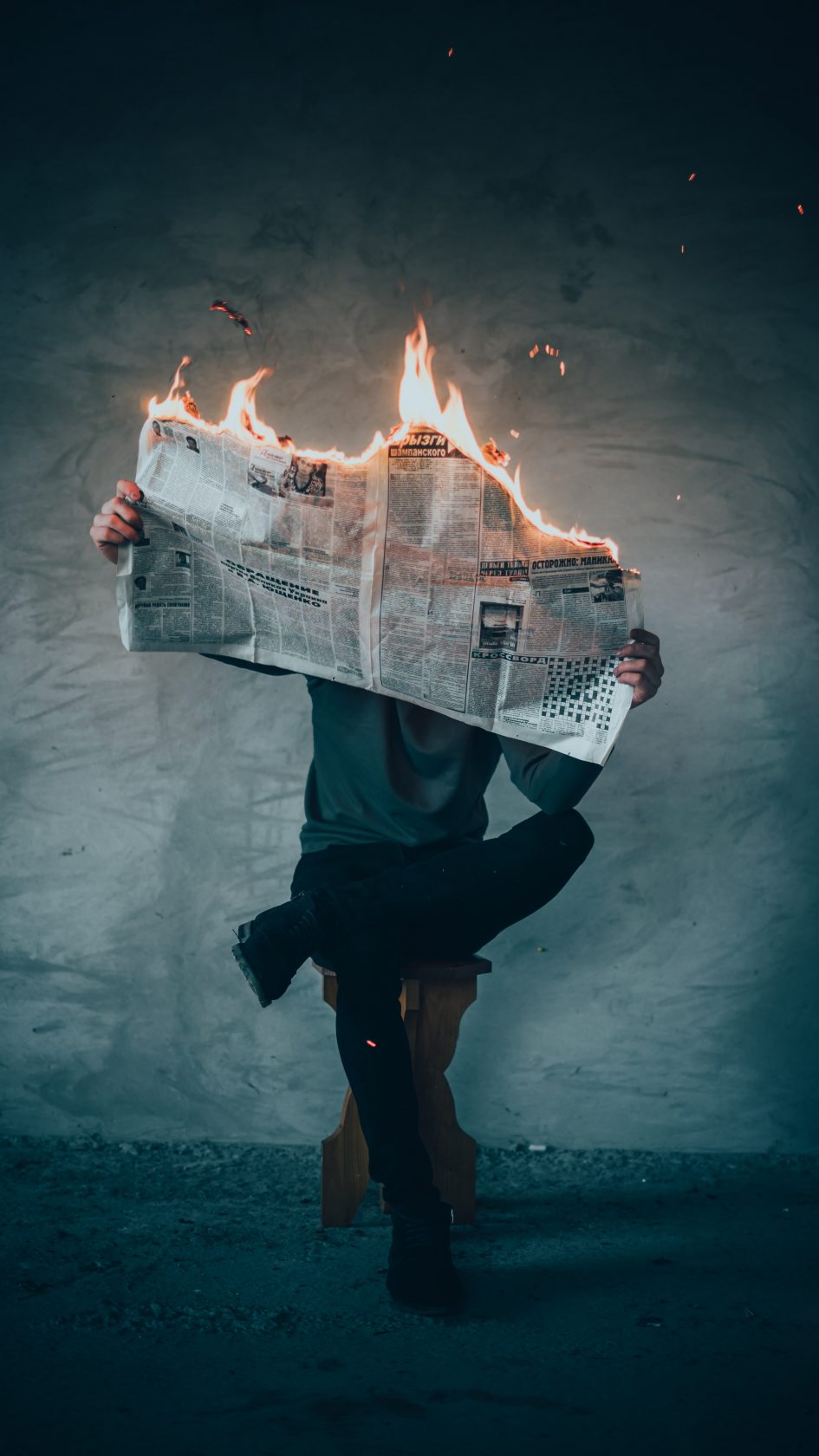 person holding newspaper that is burning